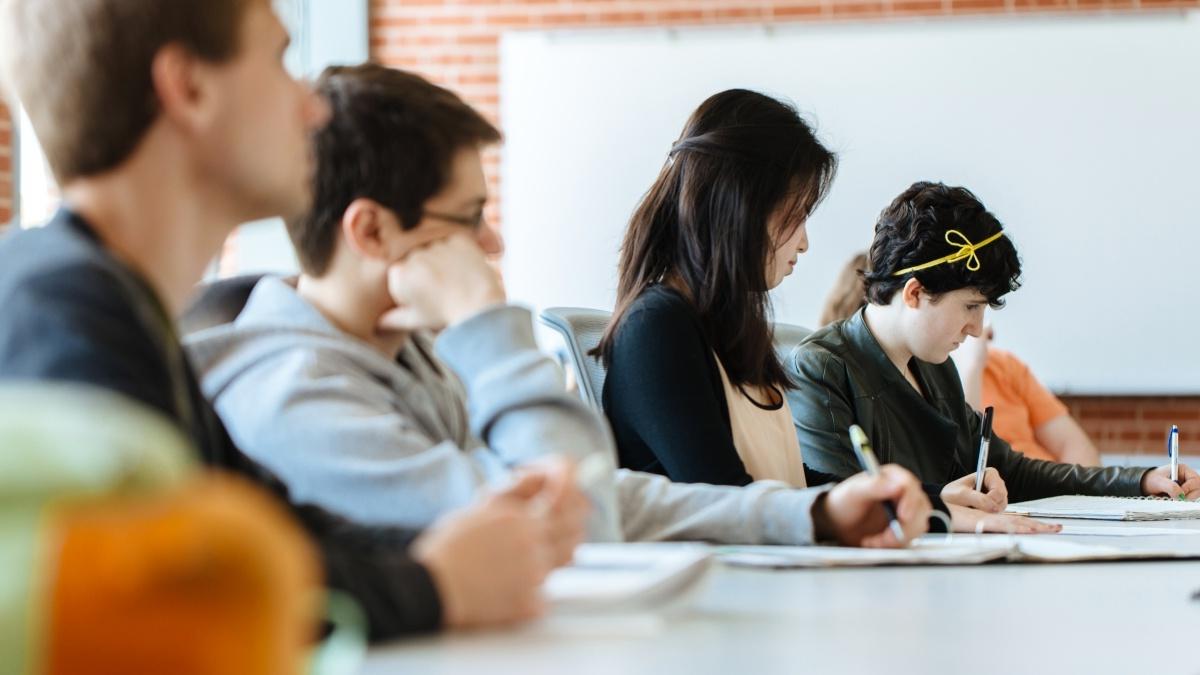 学生们坐在长桌旁听讲